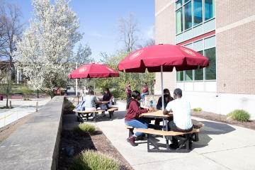 Students eating outside at picnic tables outside 多诺万餐饮中心